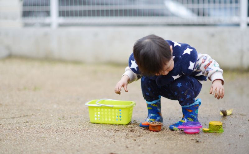 子供が公園で土を触って遊んでいる